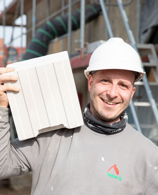 Bauhandwerker, Sanierung, Instandhaltung und Renovierung von Immobilien Bauhandwerker mit Blockziegel bei der Sanierung eines Mehrfamilienhauses